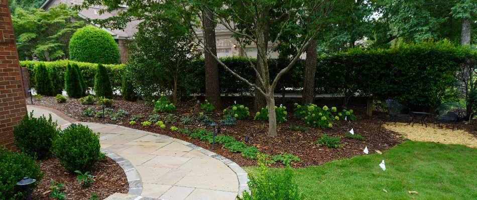 Landscape bed in Moores Mill, AL, with plants and flowers.