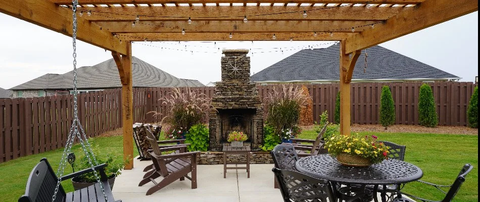 A concrete patio with an outdoor fireplace and pergola in Decherd, TN.