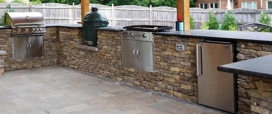 Outdoor kitchen in Huntsville, AL, with grill, griddle, and small refrigerator.