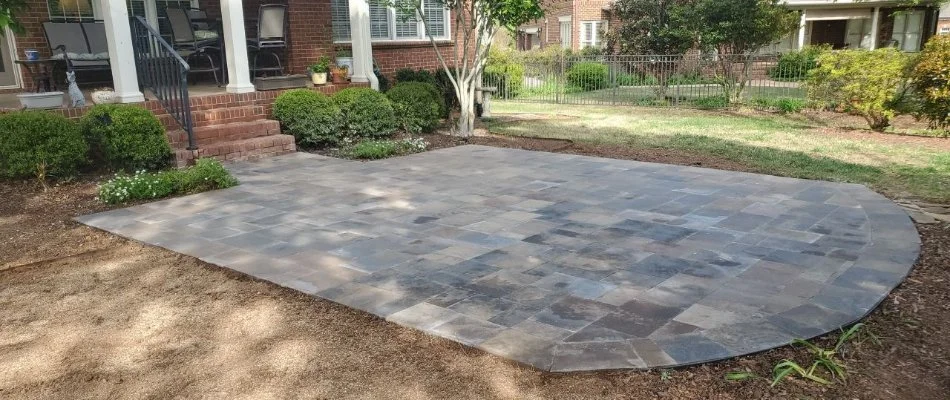 Natural stone patio with grass and shrubs.